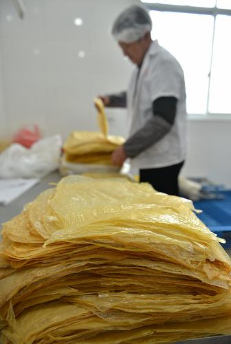 2月23日，在浙江义乌赤岸镇朱店村一家豆腐皮厂内，村民在包装豆腐皮。
