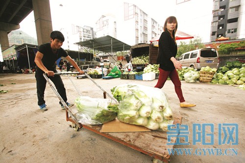 菜场中，冯成帮客户运菜