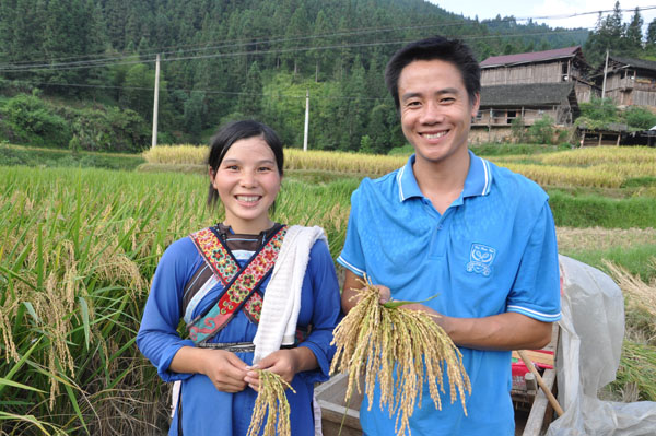 杨秀东夫妇展示成熟的稻穗