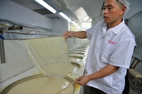 2月23日，在浙江义乌赤岸镇朱店村一家豆腐皮厂内，一名师傅成功捞制出一张豆腐皮。