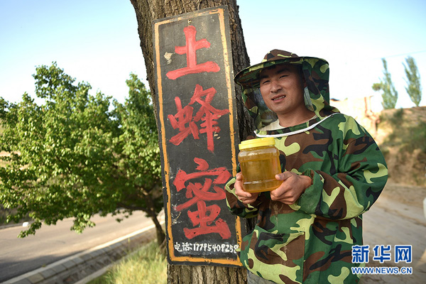 在宁夏固原市彭阳县孟塬乡小石沟村，陈泽恩展示自己的蜂蜜产品（6月21日摄）。