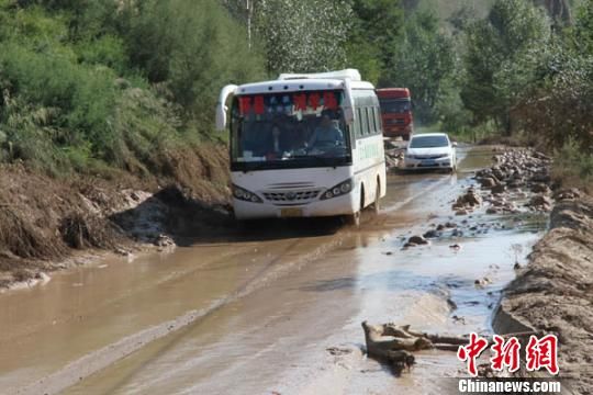 甘肃环县通往乡村公路上，冰雹暴雨引发山洪，公路上泥泞不堪。 李文 摄